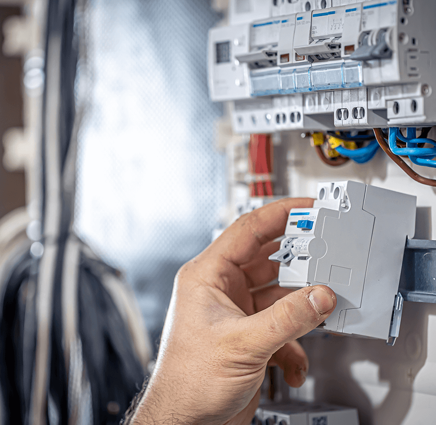 Elektrikár pripája elektrické káble v rozvádzači
